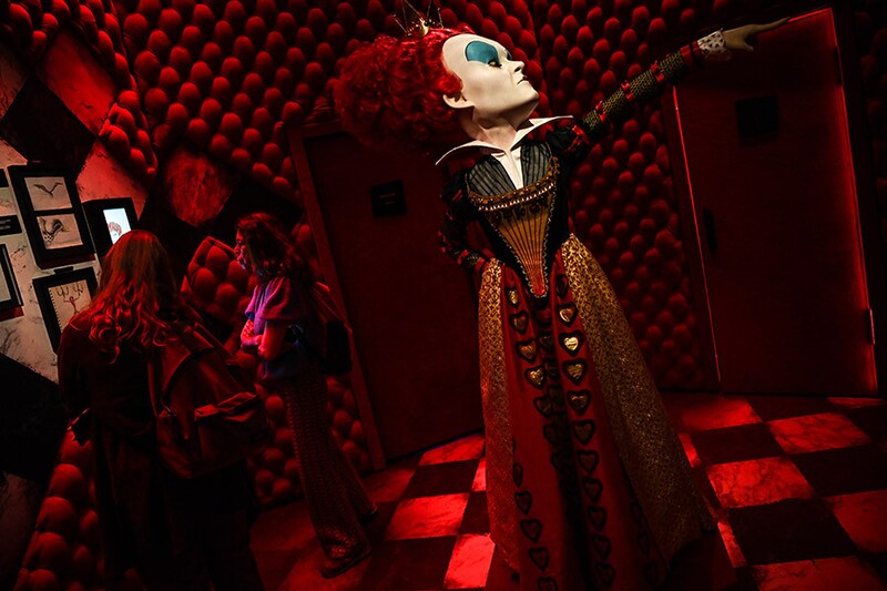 Visitors stand beside an artwork displayed as part of the "Tim Burton, The Labyrinth" exhibition during a press preview at Parc de la Villette in Paris on May 19, 2023. The immersive experience "Tim Burton, The Labyrinth", with more than 300 possible itineraries in the cult universe of the filmmaker, runs from May 19 till August 20, 2023.