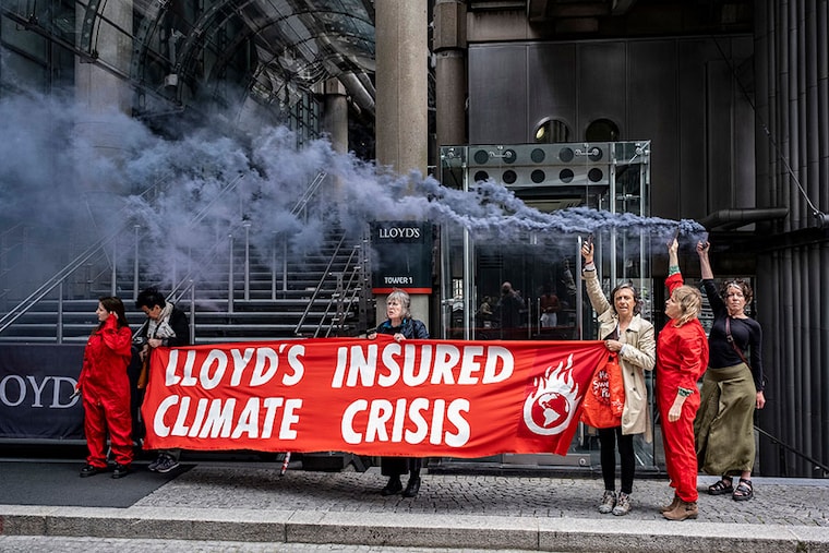 Climate activists wearing red boiler suits and letting off flares protested outside Lloyd"s building in the City of London while the Lloyds Annual General Meeting was taking place on 25th May 2023 in London, United Kingdom. The protesters were demonstrating against the insurance company that continues to insure new fossil fuel companies and projects, including the Adani Carmichael mine.