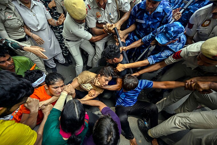 Security personnel detain wrestlers Vinesh Phogat and Sangeeta Phogat during the wrestlers" protest march towards the new Parliament building, on May 28, 2023, in New Delhi, India. The Delhi Police detained protesting wrestlers when they breached security and tried to march towards the new parliament building. The wrestlers were pushed into buses and taken to different unknown locations. The Delhi Police personnel cleared the protest site at Jantar Mantar by removing cots, mattresses, coolers, fans and the tarpaulin ceiling along with other belongings of the wrestlers.