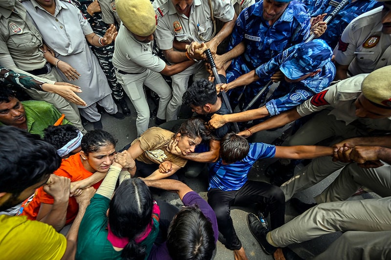 Security personnel detain wrestlers Vinesh Phogat and Sangeeta Phogat during the wrestlers" protest march towards the new Parliament building, on May 28, 2023, in New Delhi, India. The Delhi Police detained protesting wrestlers when they breached security and tried to march towards the new parliament building. The wrestlers were pushed into buses and taken to different unknown locations. The Delhi Police personnel cleared the protest site at Jantar Mantar by removing cots, mattresses, coolers, fans and the tarpaulin ceiling along with other belongings of the wrestlers.