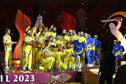 Chennai Super Kings" captain MS Dhoni (extreme left) looks at his winning team as they lift the IPL trophy in celebration after the IPL T20 final cricket match at the Narendra Modi Stadium in Ahmedabad on May 30, 2023. CSK beat Gujarat Titans in a last ball thriller amidst a record crowd of over a lakh who patiently endured a long rain delay.