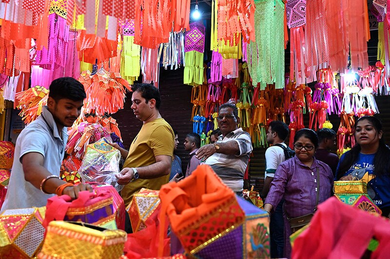 Customers buy colourful paper lanterns and other decorative items at a shop ahead of Diwali, the festival of lights, in Mumbai on November 6, 2023. Diwali will be celebrated on November 12 this year