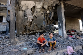 Children sit amid the rubble of a building in the aftermath of an Israeli strike in Rafah in the southern Gaza Strip on November 10, 2023, during ongoing battles between Israel and the Palestinian group Hamas.