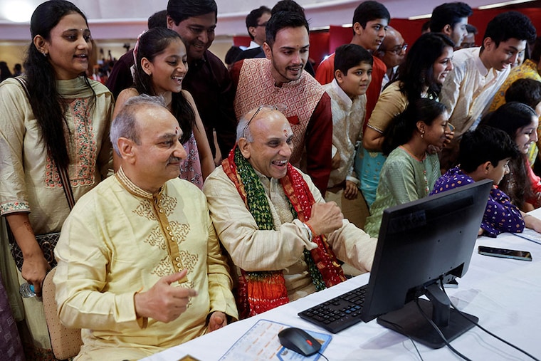 A stockbroker and his family watch a terminal during a special trading session for Diwali, the festival of lights, at the Bombay Stock Exchange (BSE) in Mumbai, India, on November 12, 2023.