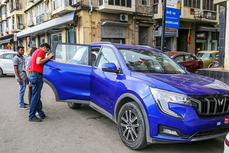 (File photo) Customers browse a Mahindra &amp Mahindra Ltd."s XUV 700 Sports Utility Vehicle (SUV) parked along a street outside a company"s dealership in Mumbai, India, on Wednesday, Aug. 3, 2022. Image: Dhiraj Singh/Bloomberg