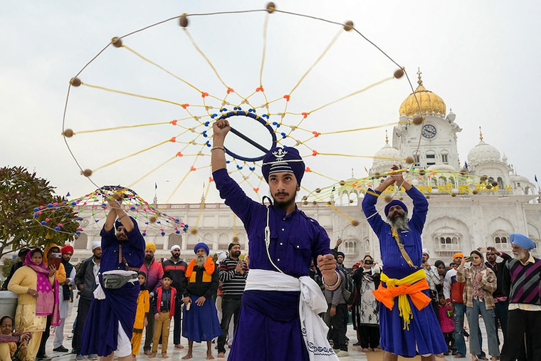 Sikhs perform "Gatka" an ancient form of martial arts, during a religious procession at the Golden Temple on the occasion of the birth anniversary of Guru Nanak Dev, the founder of Sikhism, in Amritsar on November 27, 2023.