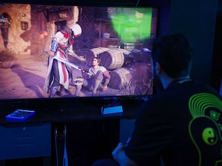 A man plays the newly released video game "Assassin"s Creed Mirage" in a cybercafe in Baghdad on October 4, 2023.
Image: Ahmad Al-Rubaye / AFP©