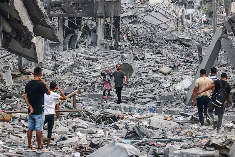 Palestinians inspect the destruction from Israeli airstrikes in Gaza City"s al-Rimal neighbourhood early on October 10, 2023. Israel kept up its deadly bombardment of Hamas-controlled Gaza on October 10 after the Palestinian militant group threatened to execute some of the around 150 hostages it abducted in a weekend assault if air strikes continued without warning.