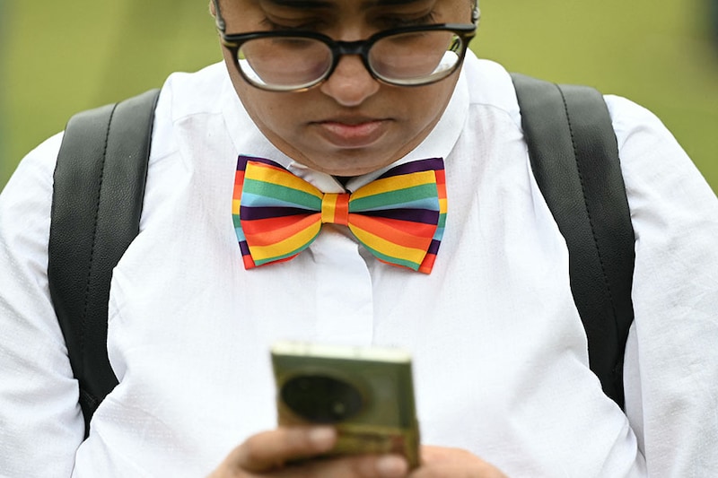 An LGBTQ activist uses a phone at the courtyard of India’s Supreme Court in New Delhi on October 17, 2023. India"s top court declined an appeal to legalise same-sex marriages in a blow to LGBTQ+ rights in the world"s most populous country. The court ruled it did not have the power to legalise same-sex marriages and said any reform to that effect would have to come from the parliament.