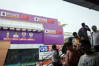 People walk past an advertising hoarding of Byju"s, outside one of its branch in New Delhi, India. Image: Reuters /Adnan Abidi