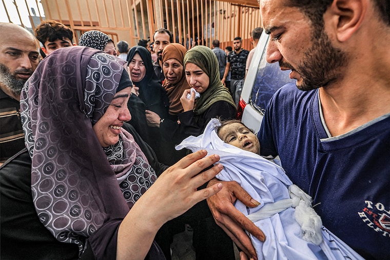 The father (R) of Amal al-Bayyouk, a one-year-old Palestinian child who was killed during Israeli bombardment, holds her body before her funeral outside the morgue at Nasser Hospital in Khan Yunis in the southern Gaza Strip on October 25, 2023, amid the ongoing battles between Israel and the Palestinian group Hamas.