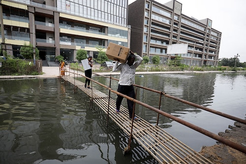 People walk on a makeshift bridge above a waterlogged street in Ahmedabad Image: Amit Dave/ Reuters