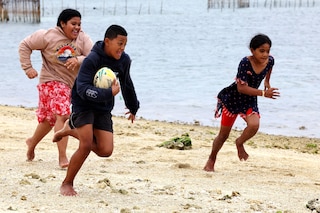 Lesieli, Siua and Sisi play a game of touch rugby by the beach at Popua on July 20, 2023, in Nuku’alofa while their families are fishing on the reef.
Image: Nuku Alofa, Tonga