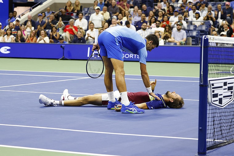 Serbia"s Novak Djokovic checks on Russia"s Daniil Medvedev as he lies on the court after the US Open tennis tournament men"s singles final match at the USTA Billie Jean King National Tennis Center in New York on September 10, 2023.