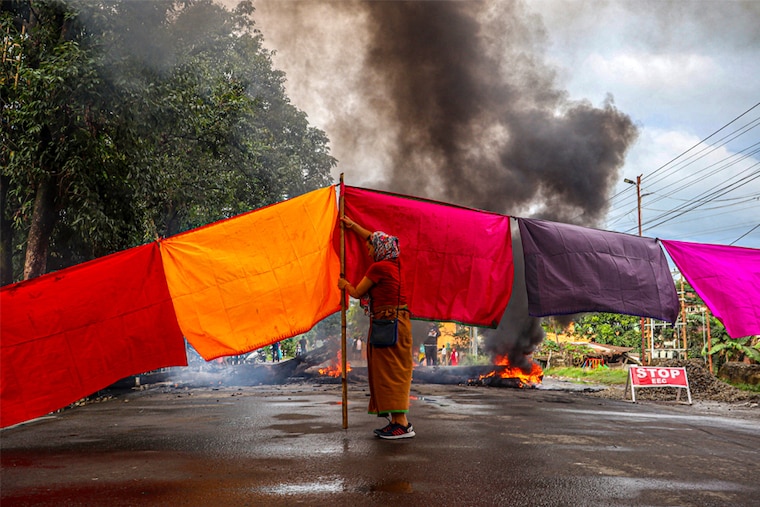 A woman protester blocks a road during a 48-hour general strike in Imphal on September 19, 2023, as they demand restoration of peace in India"s northeastern state of Manipur after ethnic violence.