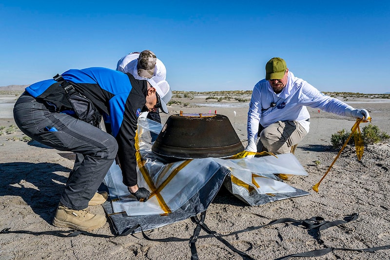 From left to right, Lockheed Martin Mission Operations Assurance Lead Graham Miller, Lockheed Martin Recovery Specialist Michael Kaye, and Lockheed Martin Recovery Specialist Levi Hanish prepare the sample return capsule from NASAà­s OSIRIS-REx mission for transport on September 24, 2023, shortly after the capsule landed at the Department of Defense"s Utah Test and Training Range in Dugway, Utah. A seven-year space voyage came to its climactic end Sunday when a NASA capsule landed in the desert in the US state of Utah, carrying to Earth the largest asteroid samples ever collected. Scientists hope the asteroid sample aboard the spacecraft will provide humanity with a better understanding of the formation of our solar system and how Earth became habitable.