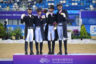 Gold medalists Sudipti Hajela, Divyakriti Singh, Vipul Chheda Hriday, Anush Agarwalla of India celebrate on the podium during the medal ceremony of the Prix St-Georges of Equestrian Dressage team event during the Hangzhou 2022 Asian Games in Hangzhou, in China"s eastern Zhejiang province on September 26, 2023.