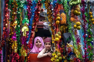 Happy kids look out at a procession amid festivities on the occasion of Eid-E-Milad-Un-Nabi, to celebrated birthday of Prophet Mohammad in Byculla on September 29, 2023 in Mumbai, India.