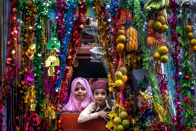 Happy kids look out at a procession amid festivities on the occasion of Eid-E-Milad-Un-Nabi, to celebrated birthday of Prophet Mohammad in Byculla on September 29, 2023 in Mumbai, India.