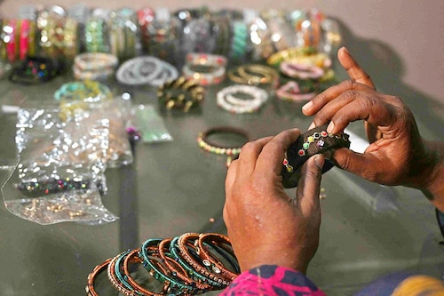 Talat Zahid adds decorative elements to bangles at a home workshop in Hyderabad. <br>Image: Asif Hassan / AFP© Talat Zahid adds decorative elements to bangles at a home workshop in Hyderabad. <br>Image: Asif Hassan / AFP©