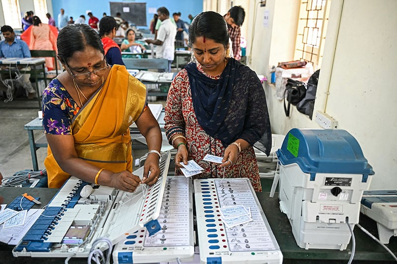 Poll officials work on Electronic Voting Machines (EVMs) at a distribution centre in Coimbatore on April 11, 2024, ahead of the country"s upcoming general elections.