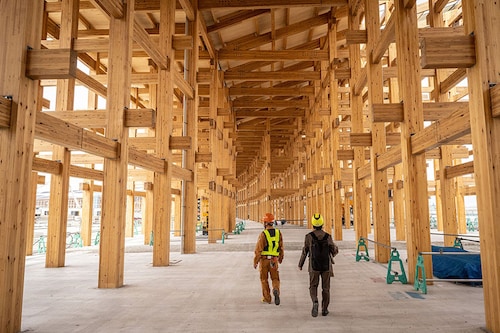 Workers walking under the construction of the "Grand Roof", known as the Ring, one of the world"s largest wooden structures, at the site of the 2025 Expo
Image: Yuichi Yamazaki / AFP© Workers walking under the construction of the "Grand Roof", known as the Ring, one of the world"s largest wooden structures, at the site of the 2025 Expo
Image: Yuichi Yamazaki / AFP©