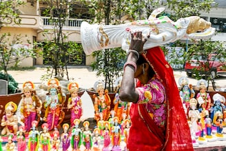 A vendor carries an idol of Lord Ram to arrange it along with other Hindu deities by the roadside in Hyderabad on April 16, 2024, on the eve of Ram Navami festival.