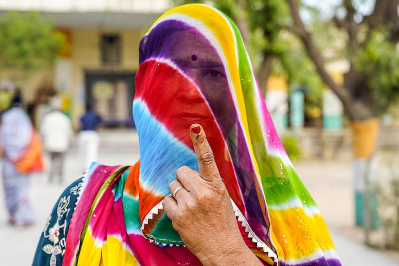A woman shows her inked finger after casting her ballot to vote in the first phase of India"s general elections at a polling station, in Parbatsar, Rajasthan, on April 19, 2024.