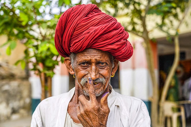 A man shows his inked finger after casting his ballot at a polling station during the second phase of voting of India"s general elections in Masuda, Rajasthan state, on April 26, 2024.