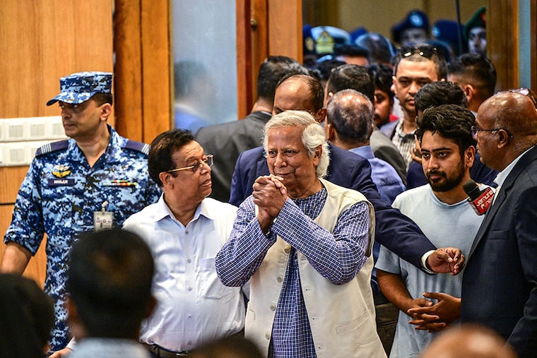 Nobel laureate Muhammad Yunus (C) greets journalists as he arrives for the press conference at the Hazrat Shahjalal International Airport in Dhaka on August 8, 2024. Muhammad Yunus returned to Bangladesh to lead a caretaker government after a student-led uprising ended the 15-year rule of Sheikh Hasina.