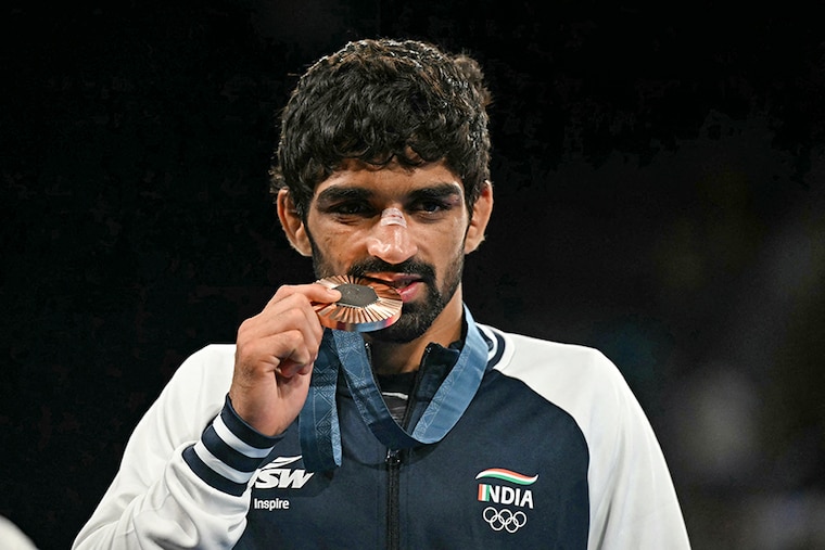 India"s Aman Sehrawat poses with his bronze medal after the presentation ceremony for the men"s freestyle 57kg wrestling event at the Champ-de-Mars Arena during the Paris 2024 Olympic Games, in Paris on August 9, 2024.