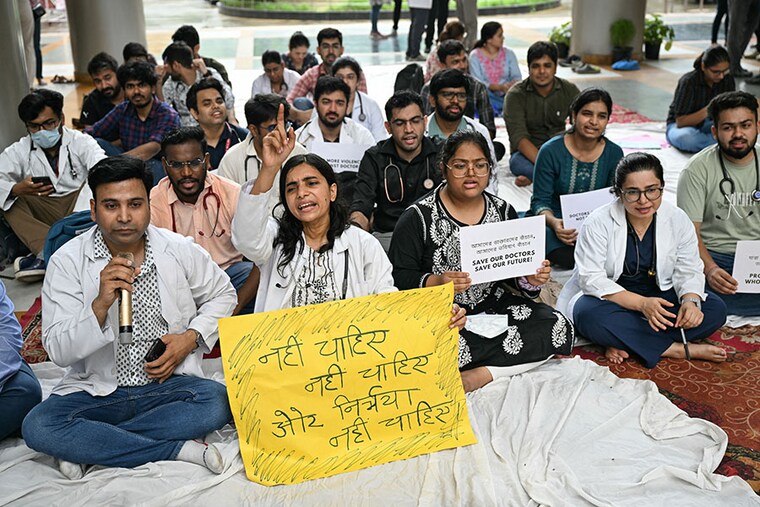 Doctors and medical staff display placards as they take part in a protest against the incident of rape and murder of a young doctor in Kolkata during a demonstration held at a government hospital in New Delhi on August 12, 2024. Doctors in government hospitals across several Indian states halted elective services "indefinitely" on August 12.