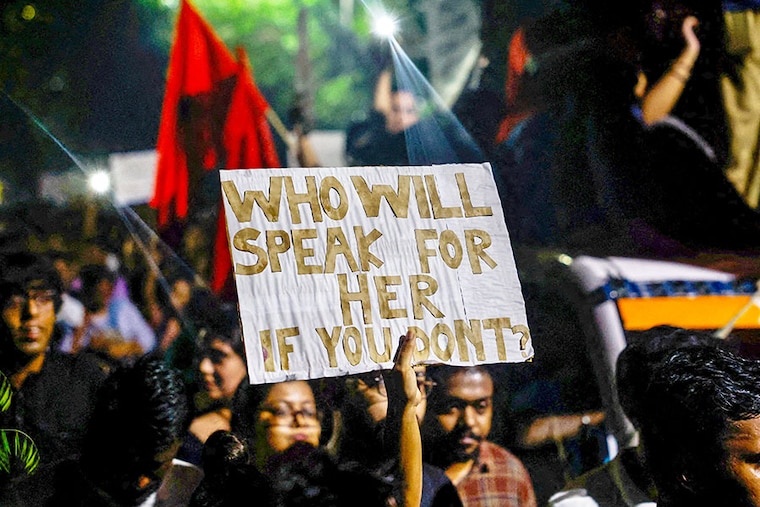 Woman holds a placard as she attends a candlelight vigil held outside Jadavpur University campus on August 15, 2024, condemning the rape and murder of a trainee doctor at a government-run hospital, RG Kar, in Kolkata, India.