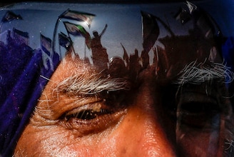 Protesters are reflected on a man"s helmet, as farmers begin to march towards New Delhi starting Dec 6, 2024, to press for better crop prices promised to them in 2021. Seen here at the Shambhu barrier, a border crossing between Punjab and Haryana states.
