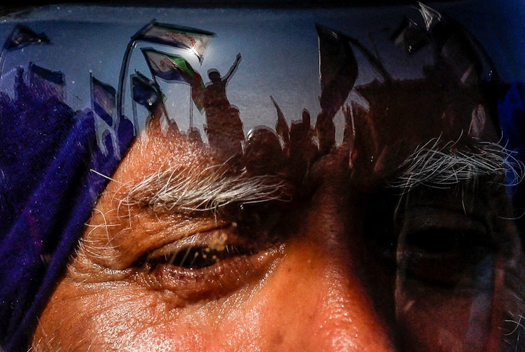 Protesters are reflected on a man"s helmet, as farmers begin to march towards New Delhi starting Dec 6, 2024, to press for better crop prices promised to them in 2021. Seen here at the Shambhu barrier, a border crossing between Punjab and Haryana states.