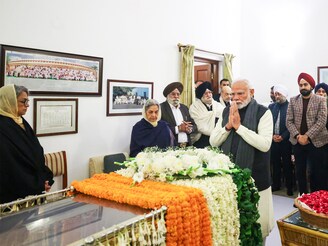 In this handout photograph taken on December 27, 2024 and released by the Indian Press Information Bureau (PIB), India"s Prime Minister Narendra Modi (C) pays last respects to former Indian Prime Minister Dr. Manmohan Singh at his residence in New Delhi. India announced seven days of state mourning after the death of former prime minister Manmohan Singh, one of the architects of the country"s economic liberalisation in the early 1990s.