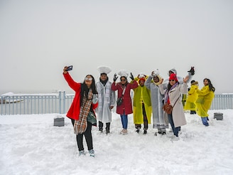 Tourists enjoying at Dal Lake during the snowfall on December 28, 2024, in Srinagar, India. The Kashmir Valley received the season"s heaviest snowfall on Saturday which threw normal life out of gear, affecting air, rail and road traffic as well as disrupting power and water supply. Image: Waseem Andrabi/Hindustan Times via Getty Images