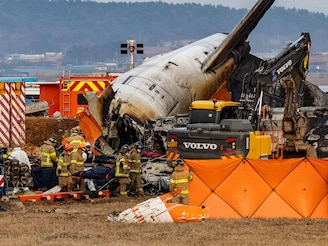 Fire authorities search for the missing and recover the deceased at the site of an accident near Muan International Airport in Jeollanam-do, South Korea, on December 29, 2024, where a Jeju Air passenger plane collided during landing. The accident, which claims 176 lives, leaves 3 missing, and sees 2 rescued, is the worst domestic passenger plane crash in history.