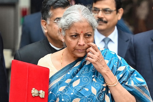 India"s Finance Minister Nirmala Sitharaman holds the briefcase containing the annual budget documents as she leaves the Finance ministry with her staff to present the budget in the parliament in New Delhi on February 1, 2024. (Photo by Sajjad HUSSAIN / AFP)