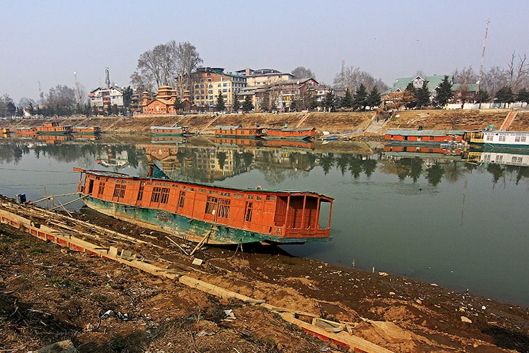 An abandoned houseboat is sitting on the dried portion of the Jhelum river as the dry spell continues. Experts are expressing concern that the Kashmir Valley has not experienced rains or snow for a long time during the winter, which is worrying not only for the agriculture sector but also because there are fears of various diseases spreading due to the drought. The water level in the Jhelum river has reached its lowest due to the prolonged dry weather, with the river flowing at -0.75 feet at Sangam in Anantnag district and -0.86 feet at Asham in Bandipora district. This is the lowest water level recorded at Sangam since November 2017, according to an official. Srinagar, Kashmir, India, on January 15, 2024.