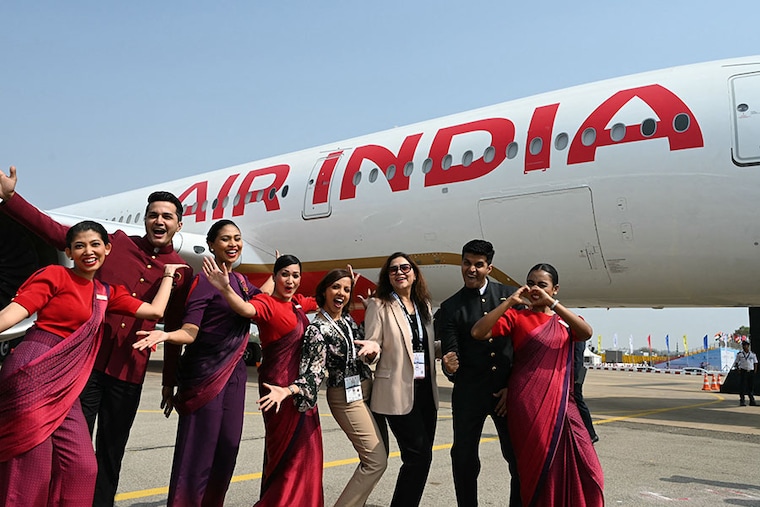 Crew members and officials of Air India pose next to India"s first Airbus A350 during "Wings India 2024", an exhibition and conference on civil aviation at the Begumpet Airport in Hyderabad on January 18, 2024. A long-range, wide-body twin-engine jet airliner developed and produced by Airbus, the innovative design with wide seats delivers spaciousness, a luxury on long-haul flights.
