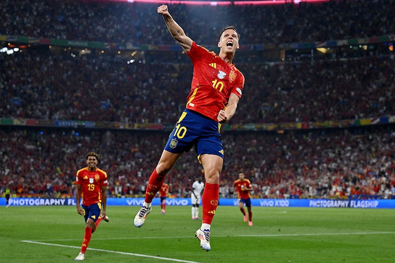 Spain"s forward Daniel Olmo celebrates France"s own goal, scored by Jules Kounde, and Spain"s second goal following his kick during the UEFA Euro 2024 semi-final football match between Spain and France at the Munich Football Arena in Munich on July 9, 2024. Spain advance to the finals after registering a 2-1 win over France.