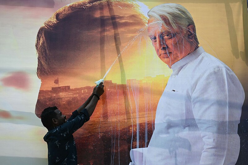 Fan of superstar Kamal Hassan splashes milk on his poster during celebration of his newly released movie "Indian 2" in Chennai on July 12, 2024.
