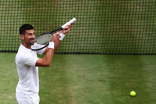 Serbia"s Novak Djokovic imitates playing the violin with his racquet as he celebrates winning against Italy"s Lorenzo Musetti during their men"s singles semi-final tennis match on the twelfth day of the 2024 Wimbledon Championships at The All England Lawn Tennis and Croquet Club in Wimbledon, southwest London, on July 12, 2024. - Djokovic won the match 6-4, 7-6, 6-4.