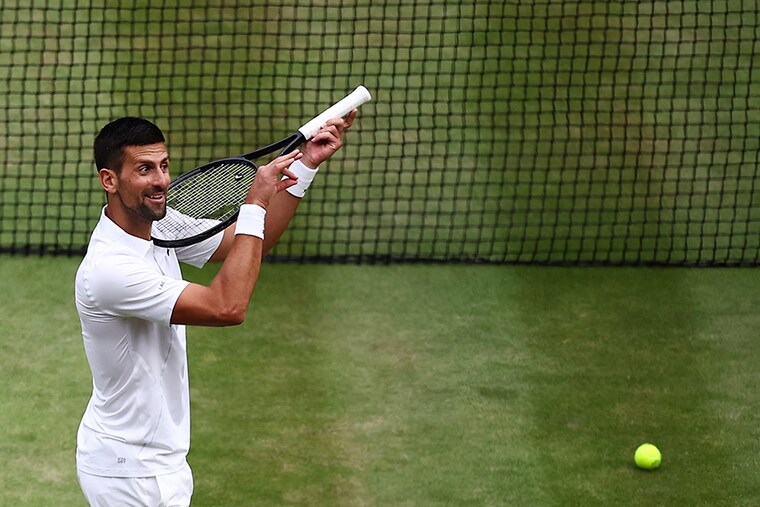 Serbia"s Novak Djokovic imitates playing the violin with his racquet as he celebrates winning against Italy"s Lorenzo Musetti during their men"s singles semi-final tennis match on the twelfth day of the 2024 Wimbledon Championships at The All England Lawn Tennis and Croquet Club in Wimbledon, southwest London, on July 12, 2024. - Djokovic won the match 6-4, 7-6, 6-4.
