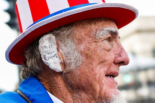Duane Schwingel, also known as "Uncle Jam", wears a bandage on his ear that reads "Fight, fight, Fight" as he stands near the Fiserv Forum on Day 3 of the Republican National Convention (RNC) in Milwaukee, Wisconsin, US, July 17, 2024.