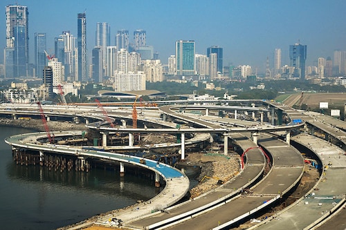Labourers work on an under construction portion of the Coastal Road expressway along the Arabian Sea coastline of Mumbai. 
Image: Indranil Mukherjee / AFP