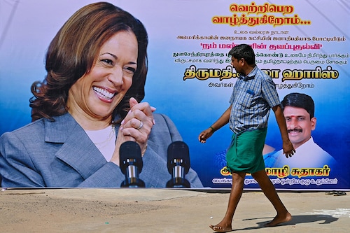 A man walks past a poster of US Vice President Kamala Harris in her ancestral village of Thulasendrapuram in the south Indian state of Tamil Nadu on July 23, 2024, after she was endorsed for the US presidential election.