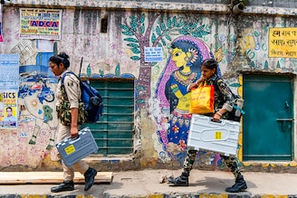 Security personnel carry Electronic Voting Machines (EVMs) and other voting materials as they leave for polling stations in Patna on May 31, 2024, on the eve of the seventh and final phase of voting in India"s general election.