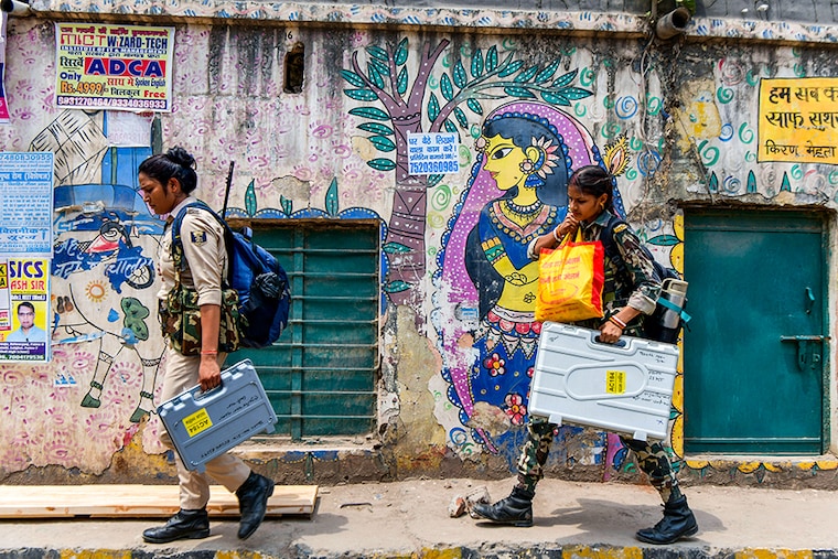 Security personnel carry Electronic Voting Machines (EVMs) and other voting materials as they leave for polling stations in Patna on May 31, 2024, on the eve of the seventh and final phase of voting in India"s general election.